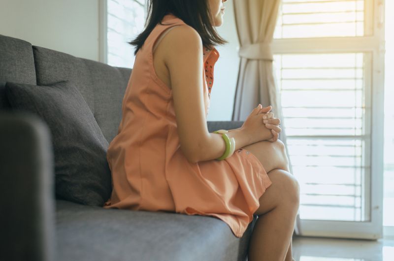 Worried woman sitting in living room